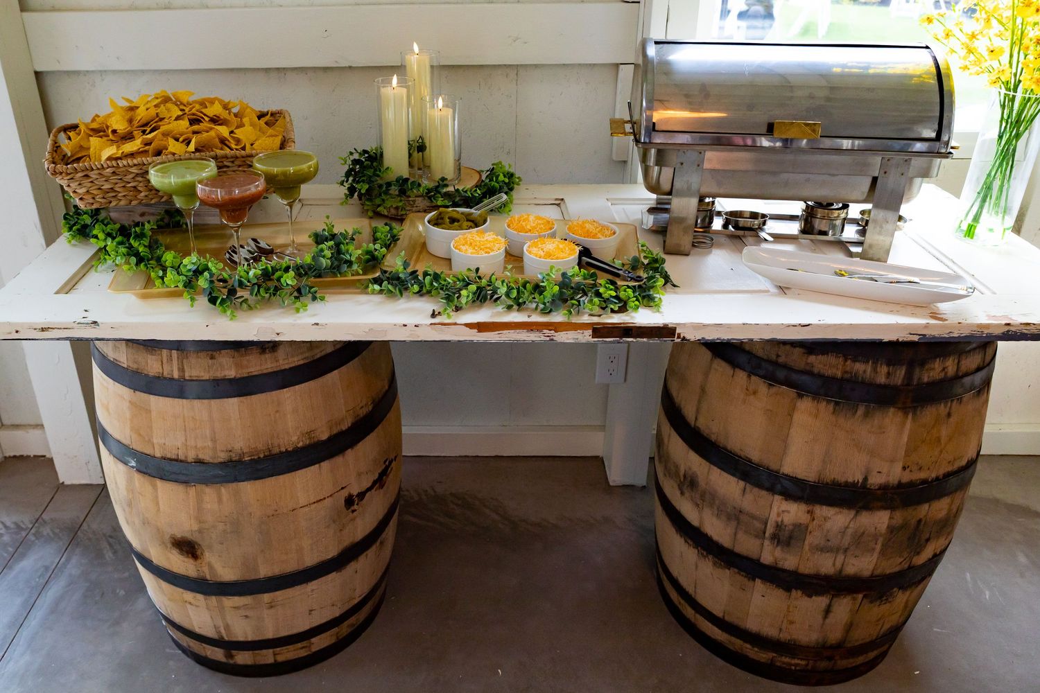 Food service station with wooden barrel base displays and buffet setup.
