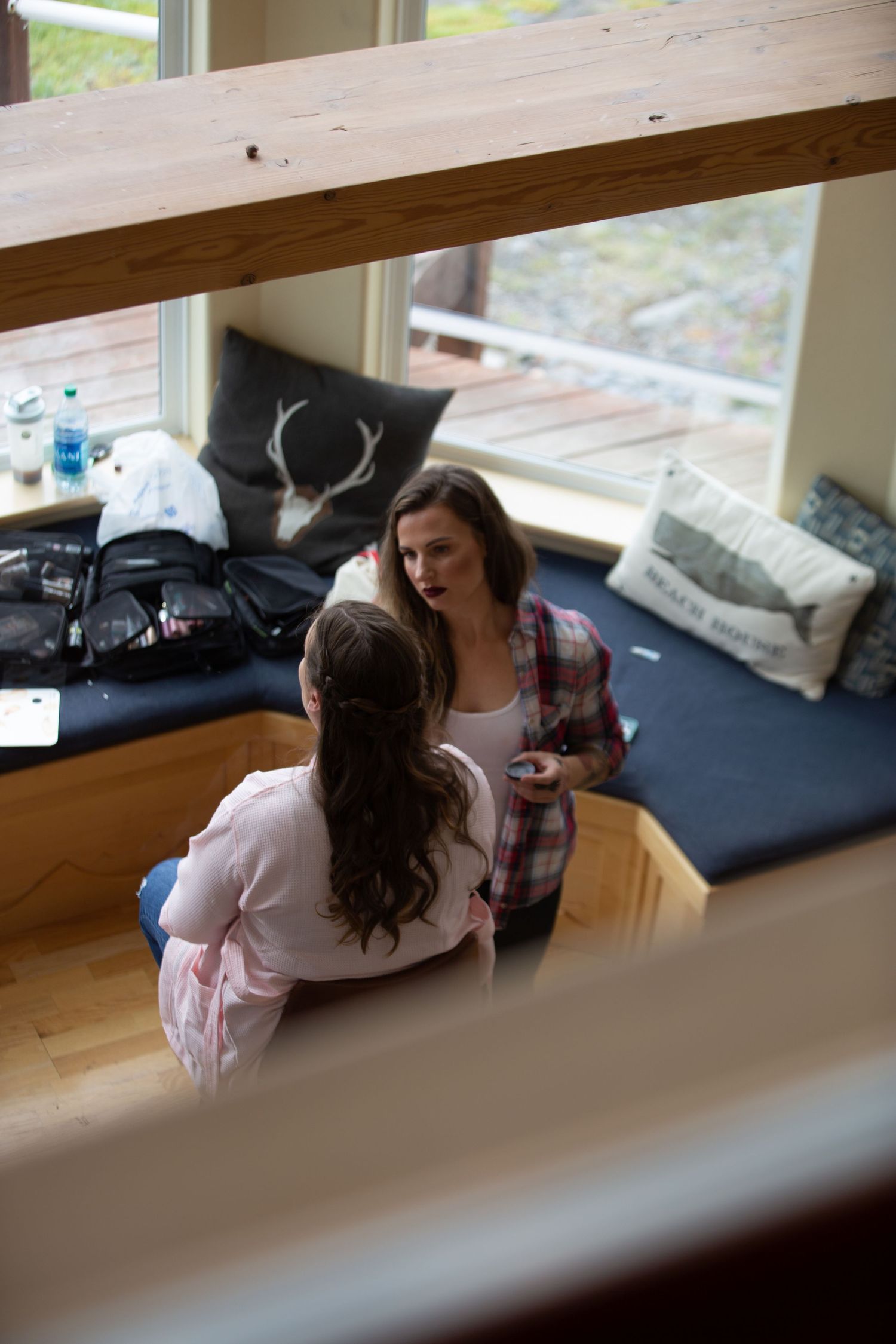People relax and chat together by a window in a casual indoor setting.