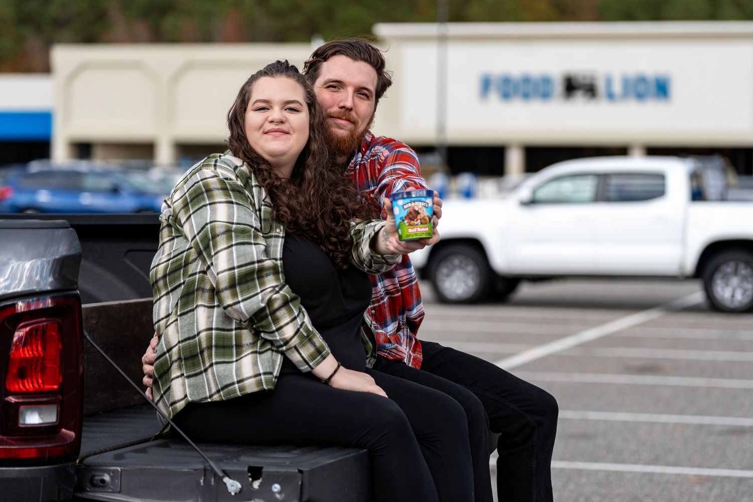 Couple in casual attire sharing a romantic moment in a parking lot.