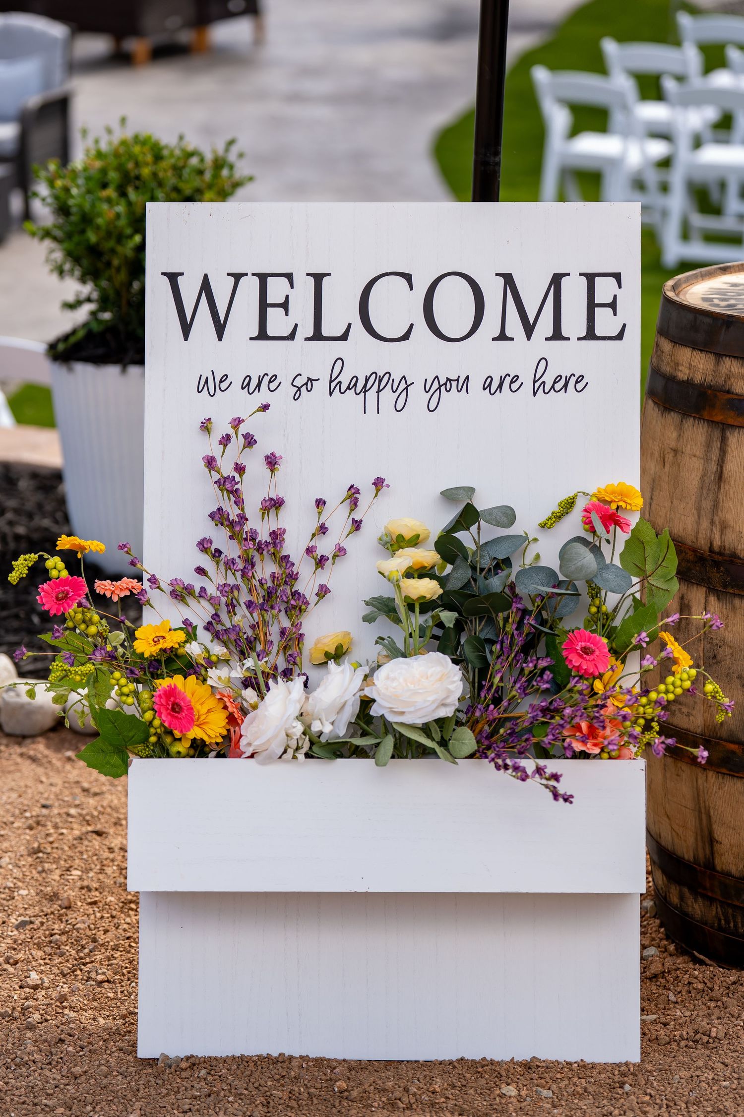 Decorative welcome signs with colorful floral arrangements featuring pink and yellow flowers.