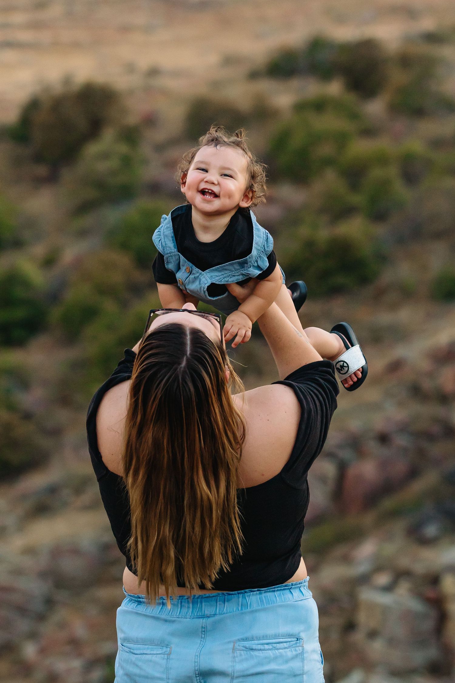 A joyful moment captured against a rocky hillside backdrop in warm natural lighting.