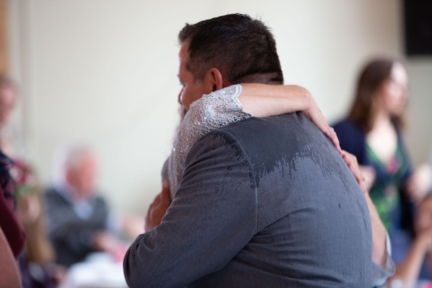 A tender embrace on a dance floor during what appears to be a wedding celebration or special event.