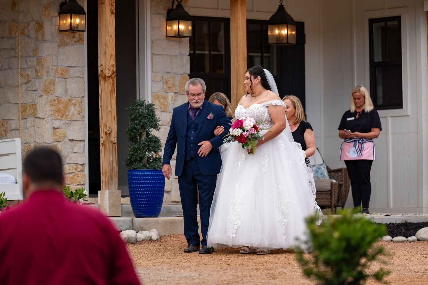 Wedding guests gathering outside a stone facade building during celebration.