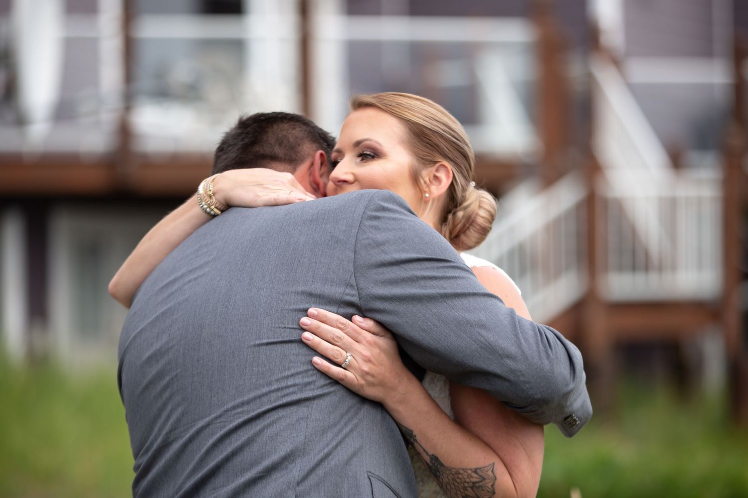 Intimate embrace between couple with bride's hand on groom's back.