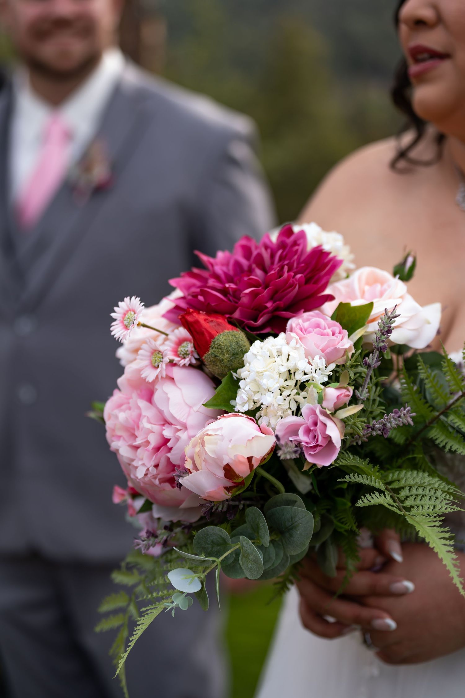 Stunning pink and burgundy wedding bouquet with peonies, ferns and mixed flowers.