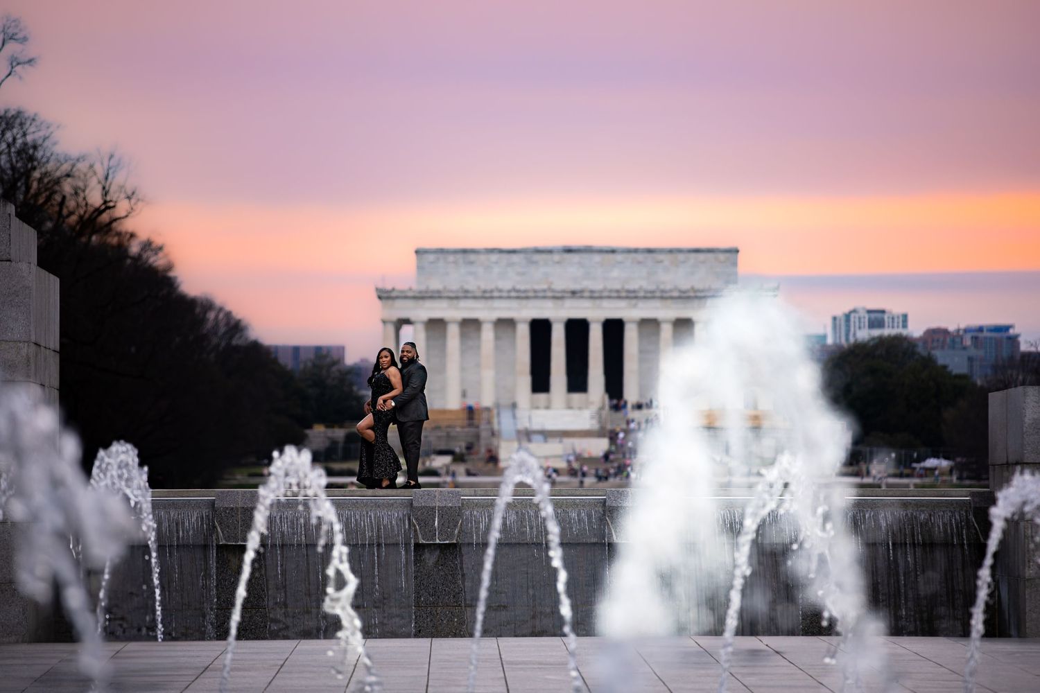 The Lincoln Memorial glows at sunset behind the World War II Memorial fountains in Washington DC.