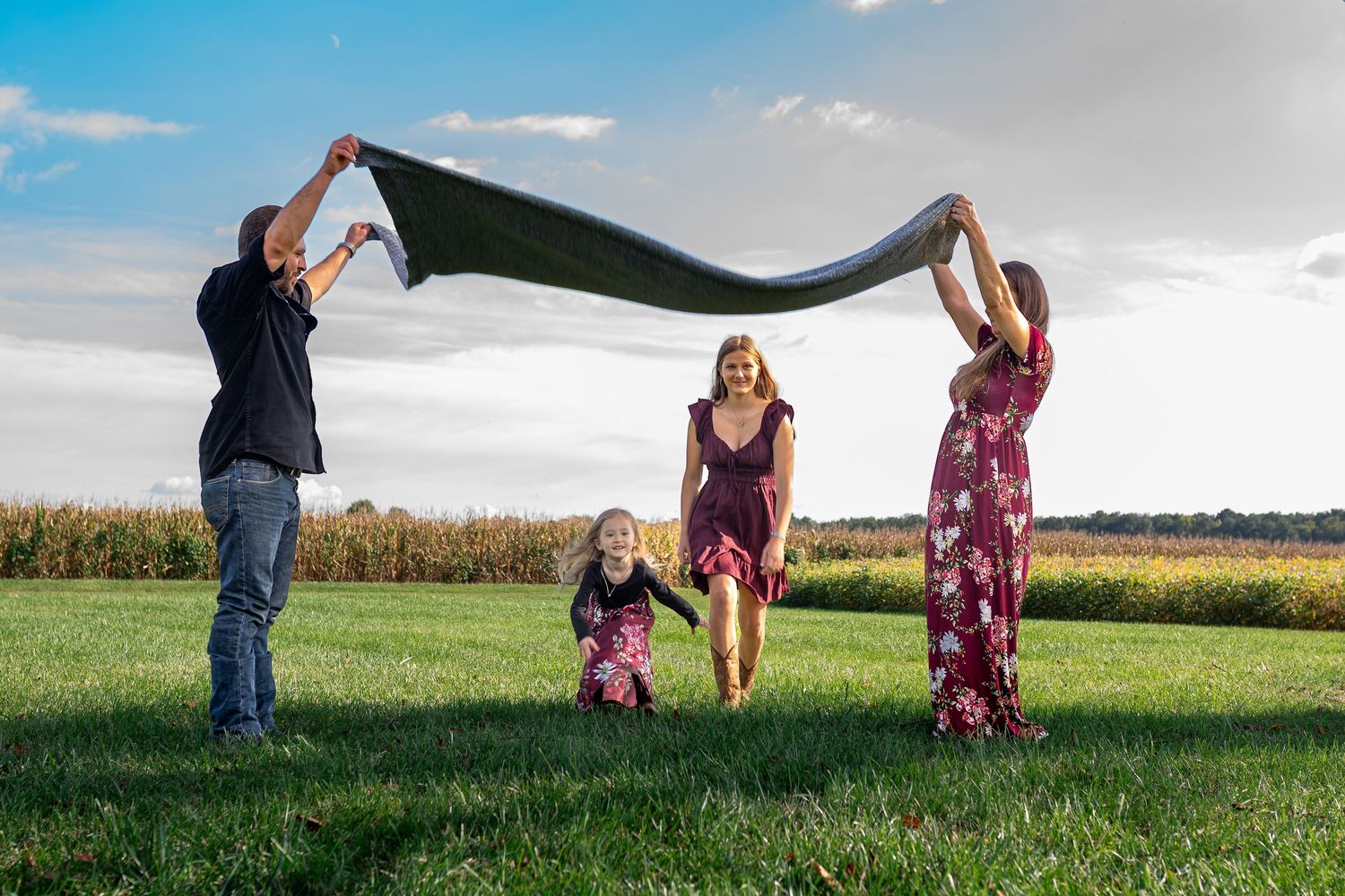 Group photo session with dramatic sky and cornfield backdrop.