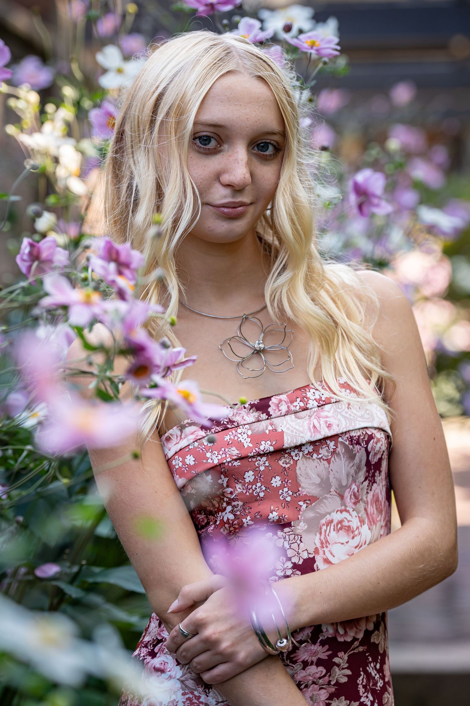 Close-up portraits framed by pink flowering branches in soft lighting.