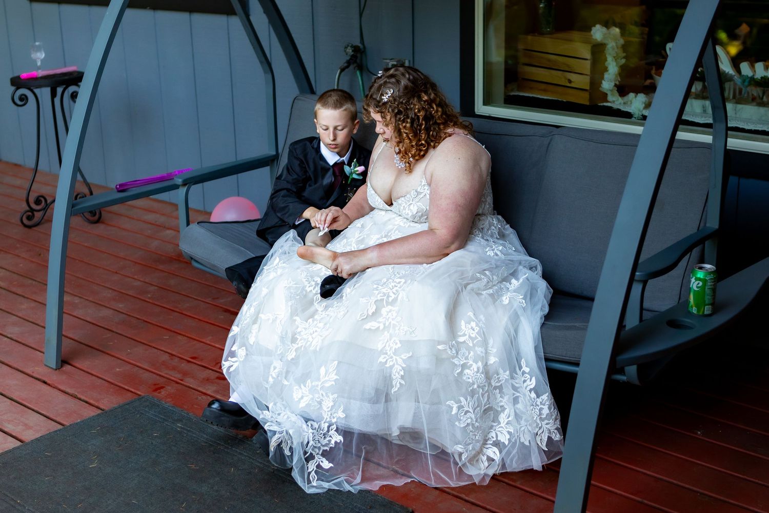 A couple enjoying a quiet moment on a wooden porch during their wedding.