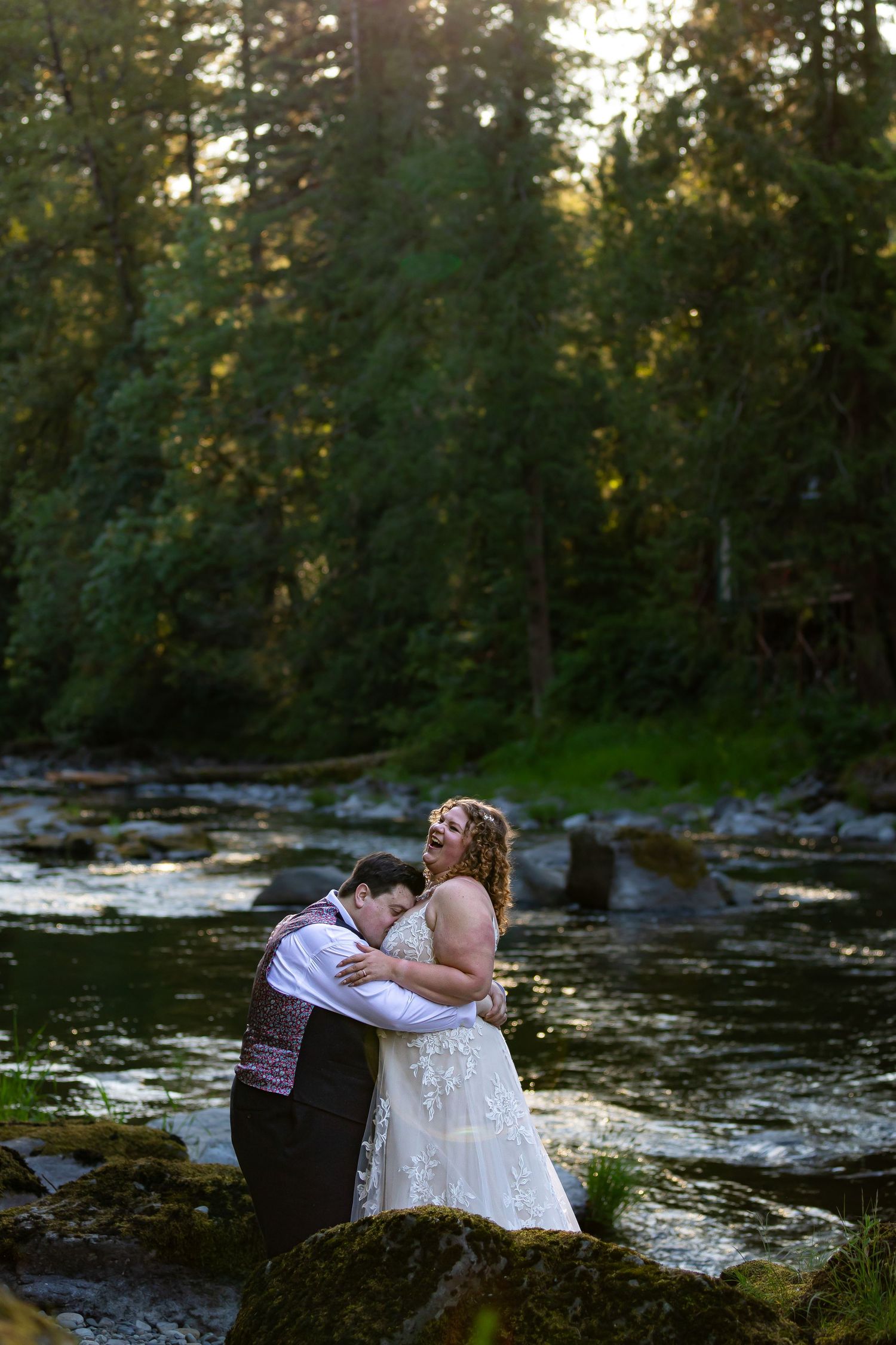Romantic wedding photos by a scenic forest river at sunset.