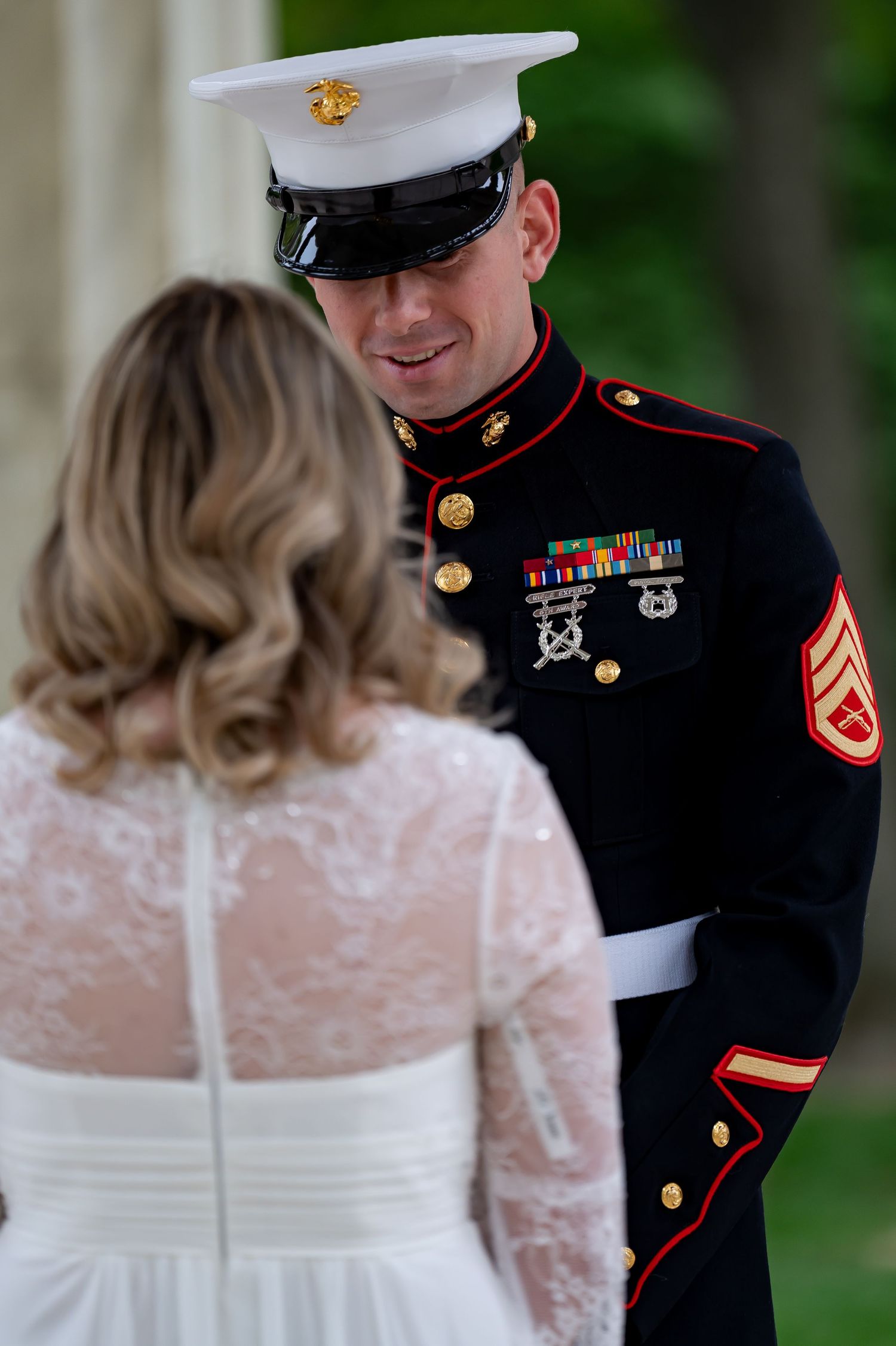 Military wedding couple sharing intimate moment in formal dress uniforms.