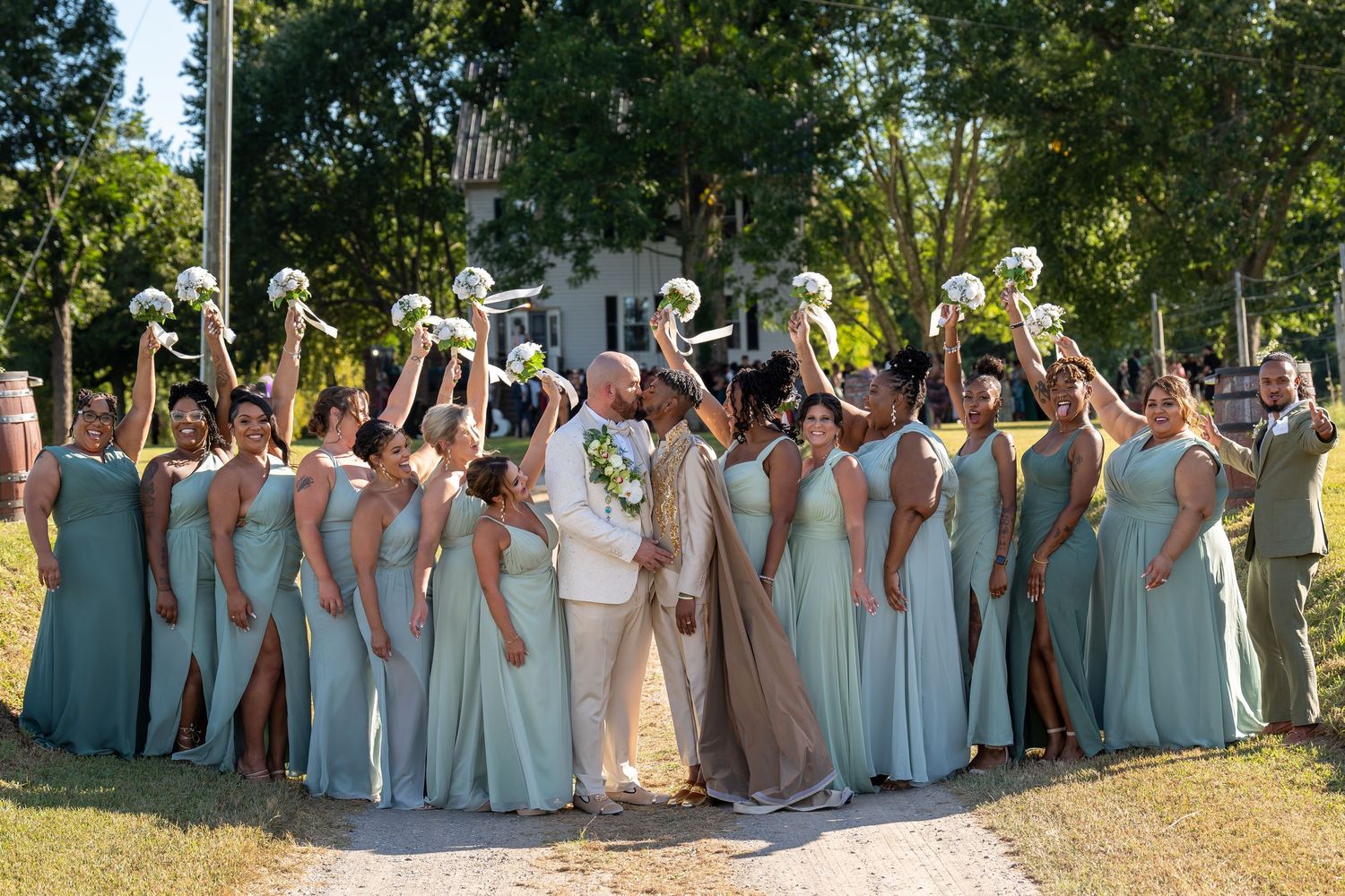 Wedding party in light blue dresses posed together outdoors.