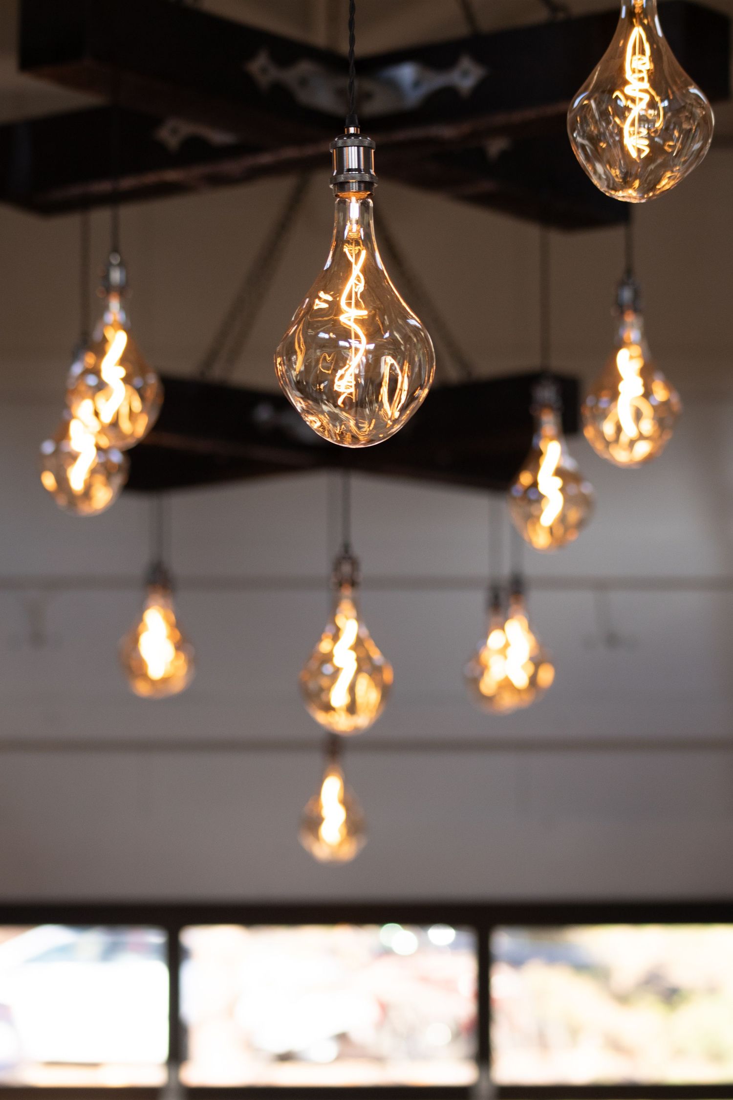 Vintage-style Edison bulb pendant lights hanging from dark ceiling.