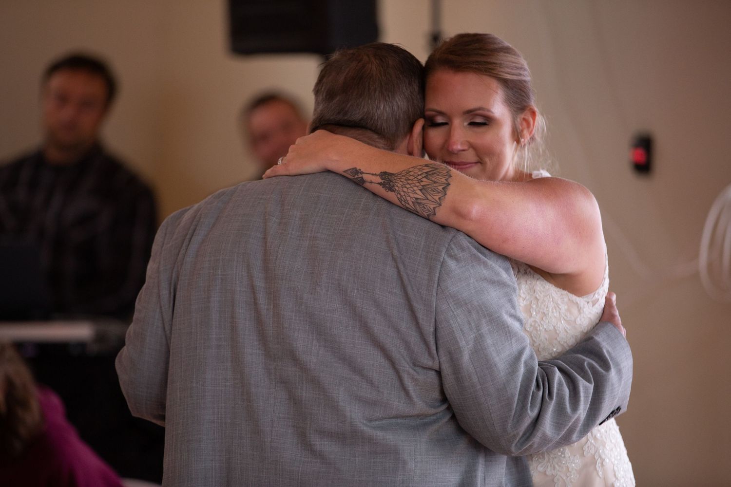 A couple shares an intimate slow dance embrace at their wedding reception.
