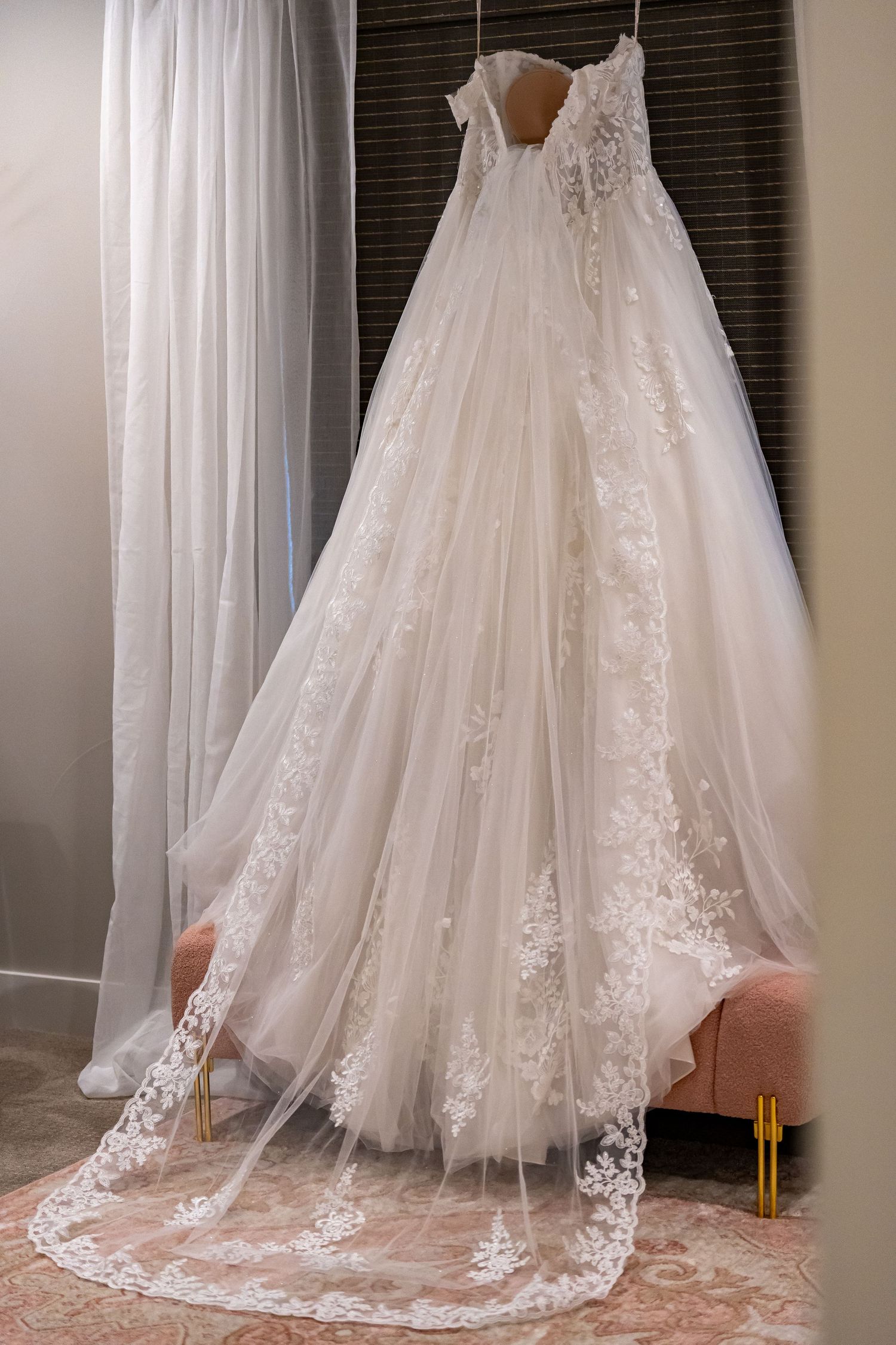 Close-up details of a white lace wedding dress train and hemline.