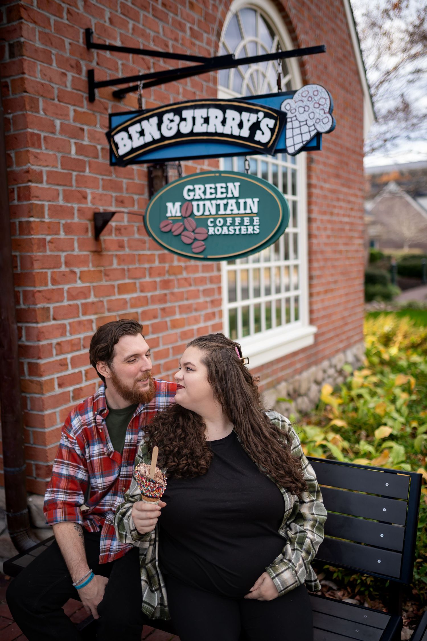 Couple sharing intimate moment outside Ben & Jerry's ice cream shop.
