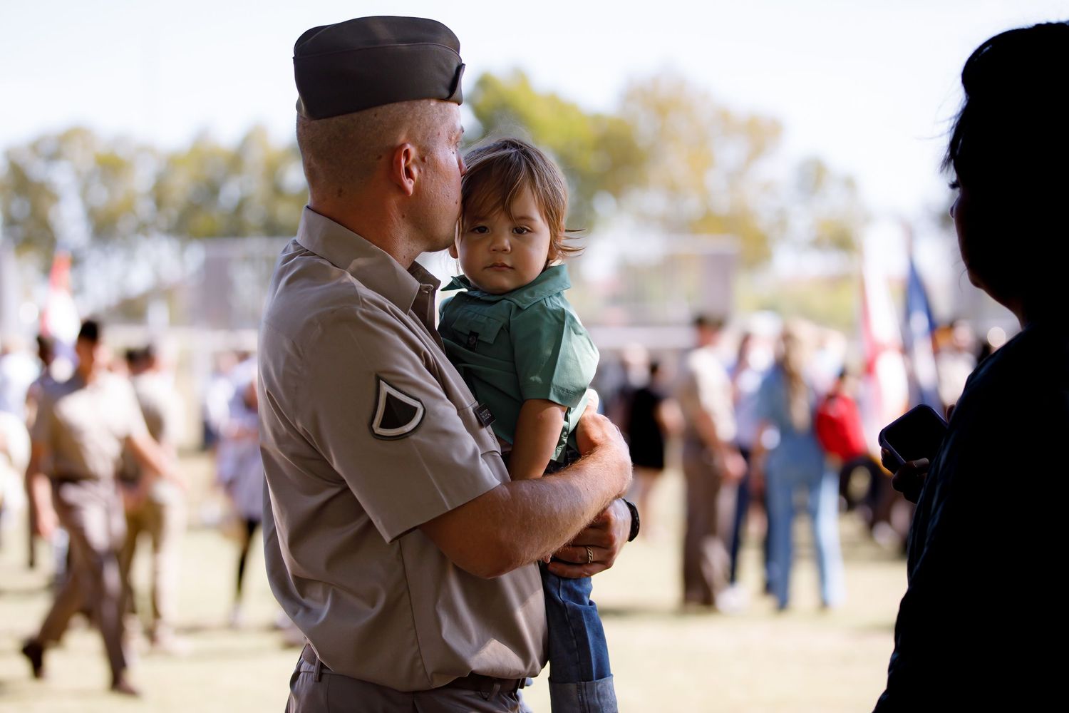 Military service members greet loved ones at a welcome home celebration.