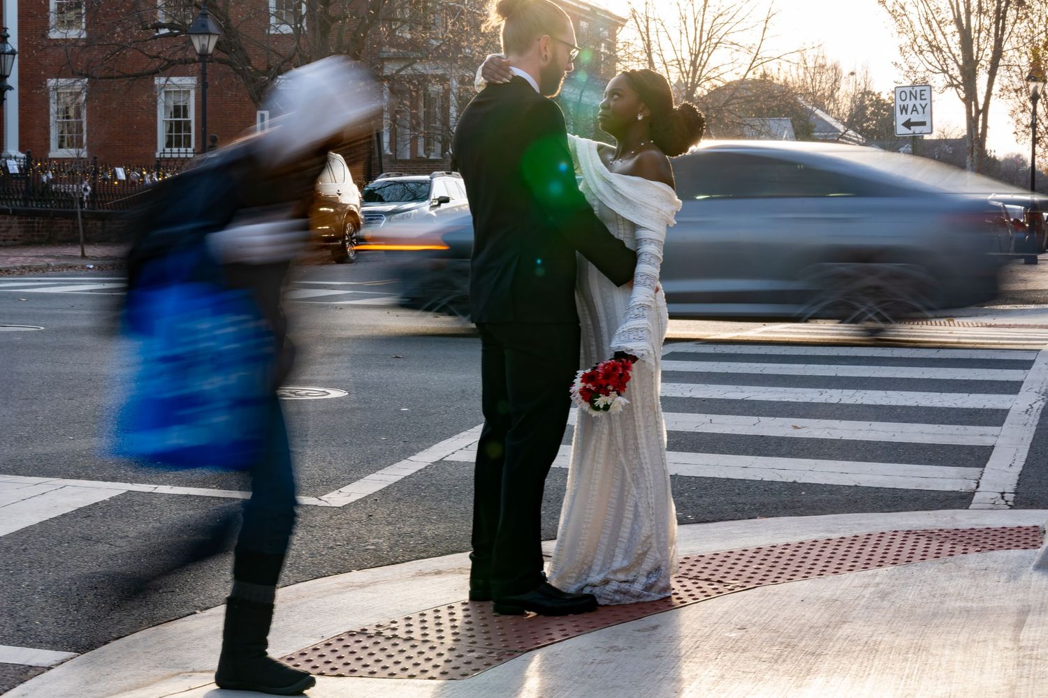 A couple photographed in motion on a city street with blurred passersby.