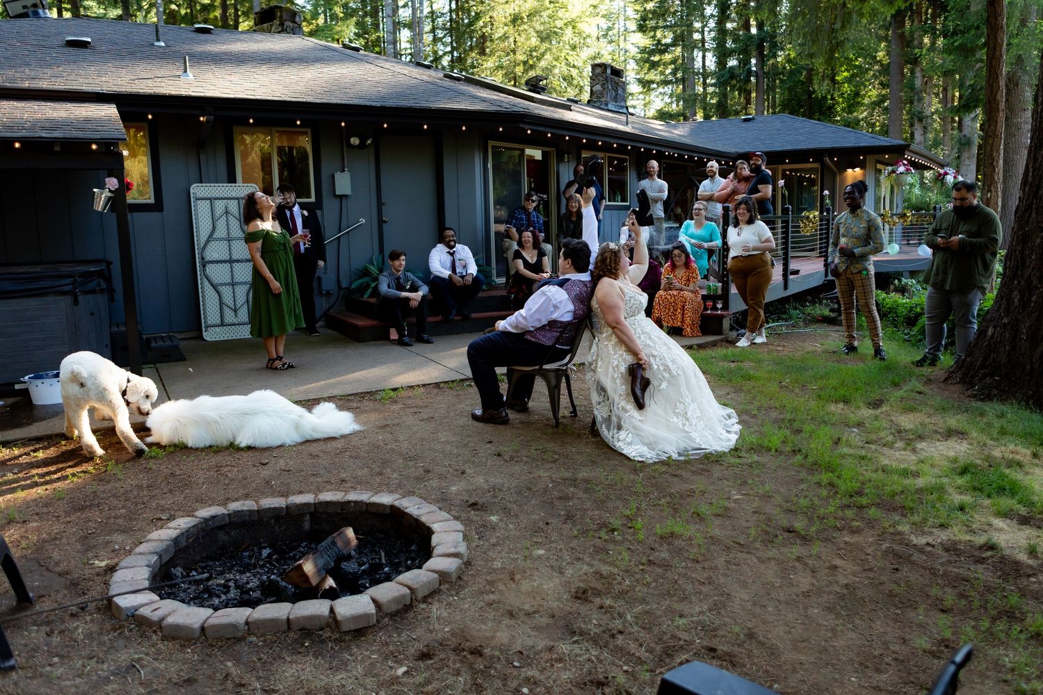 Stone fire pit surrounded by seating in a wooded outdoor event space.
