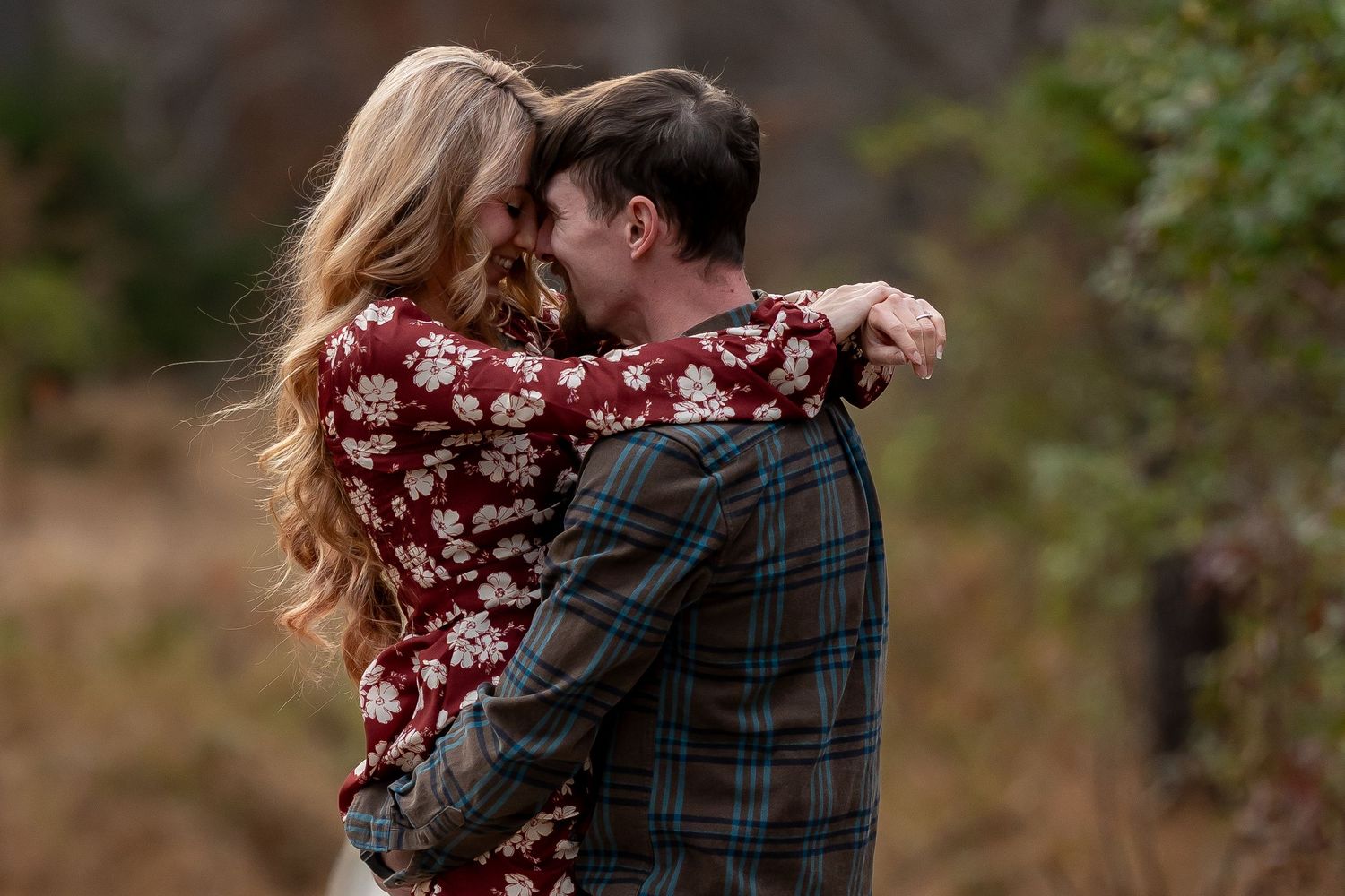 Romantic outdoor couple photoshoot with floral dress and plaid clothing.