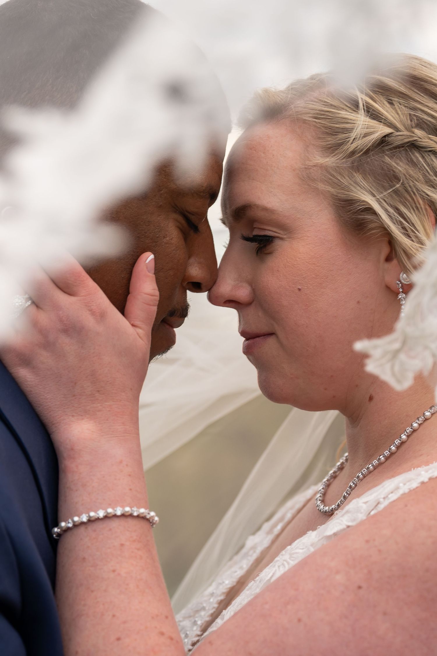 A close-up romantic moment between newlyweds during their wedding ceremony.
