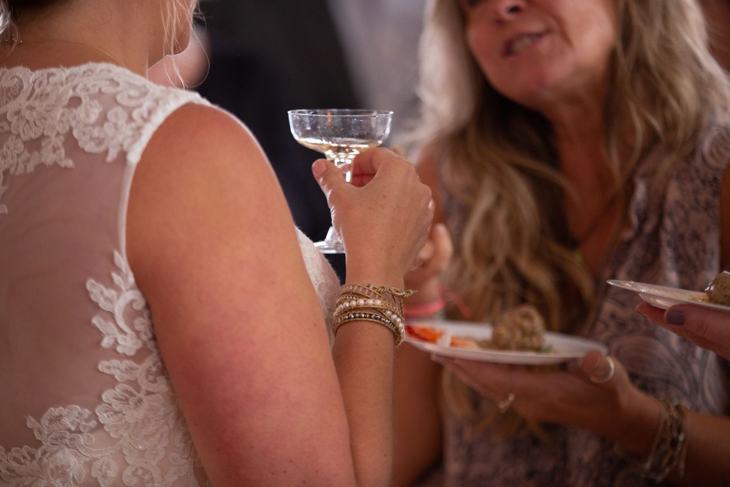 Close-up of guests holding cocktail glasses at an elegant reception.