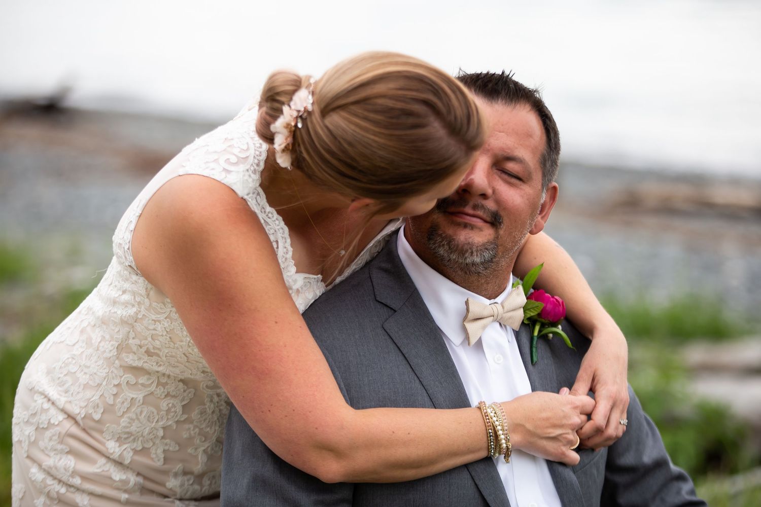 Candid emotional moment between two people at outdoor wedding.