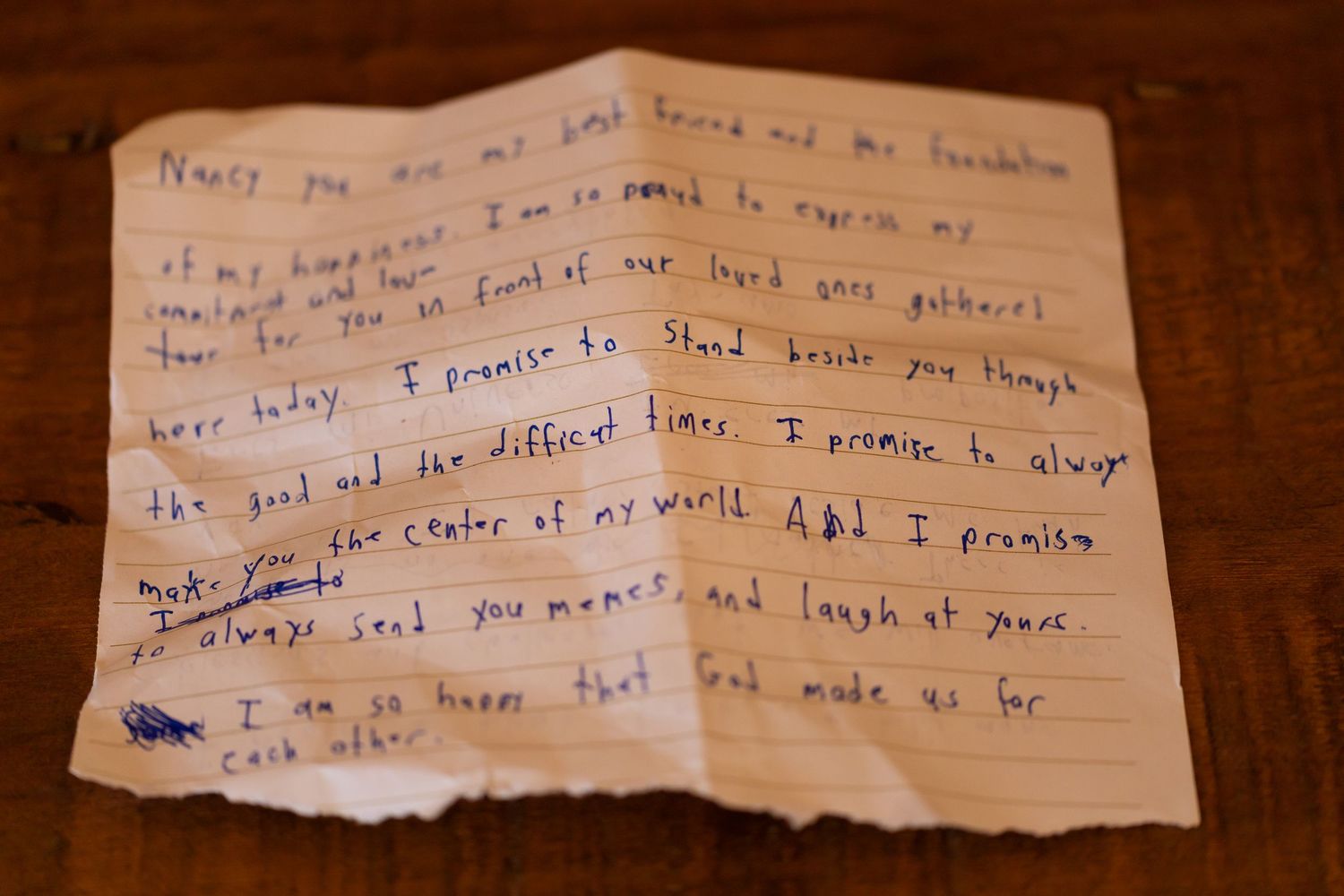 Handwritten note fragments on torn pieces of lined paper against wooden surface.