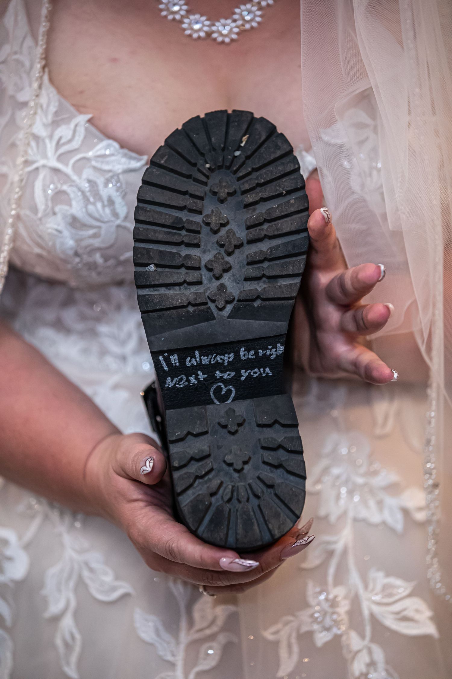 Wedding dress detail with boot sole showing handwritten message.