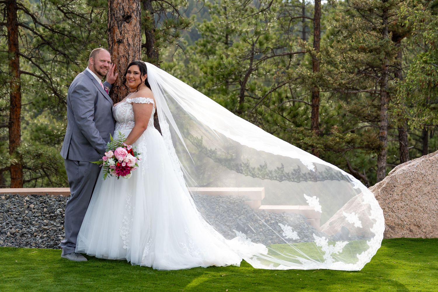 Dramatic wedding photos with flowing veil against natural mountain landscape.