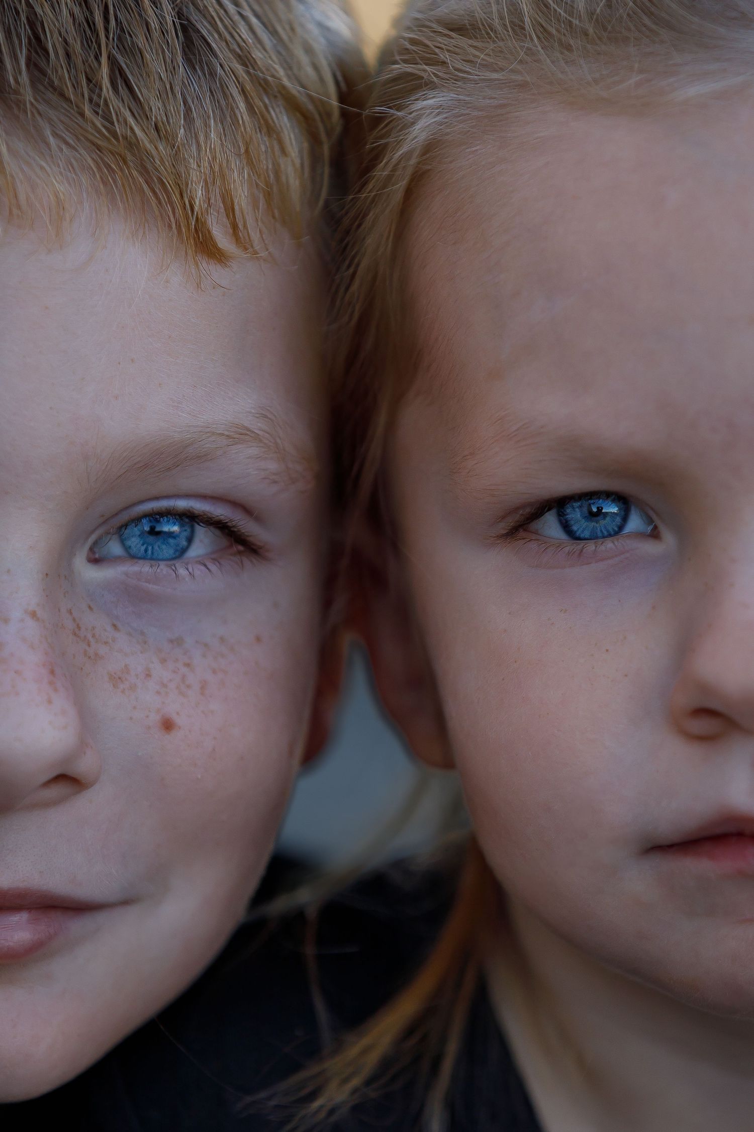 Close-up portrait showcasing striking blue eyes and freckles.