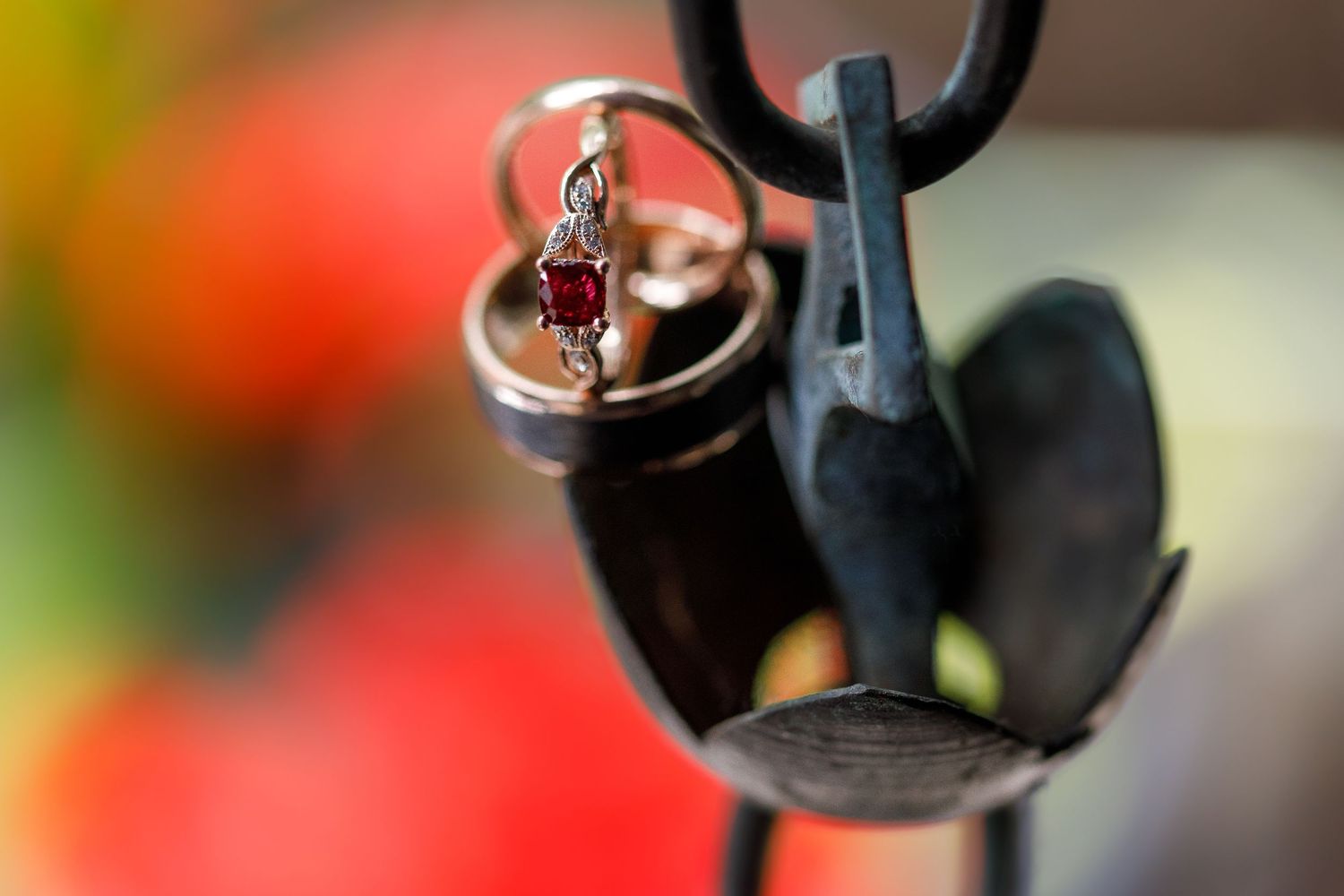 Black metal hooks against an orange and red blurred background.