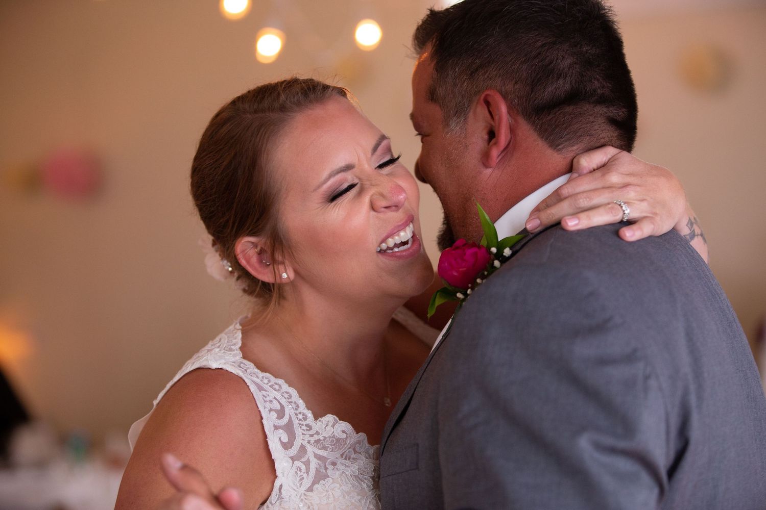 Couple shares intimate dance moment at indoor wedding reception.