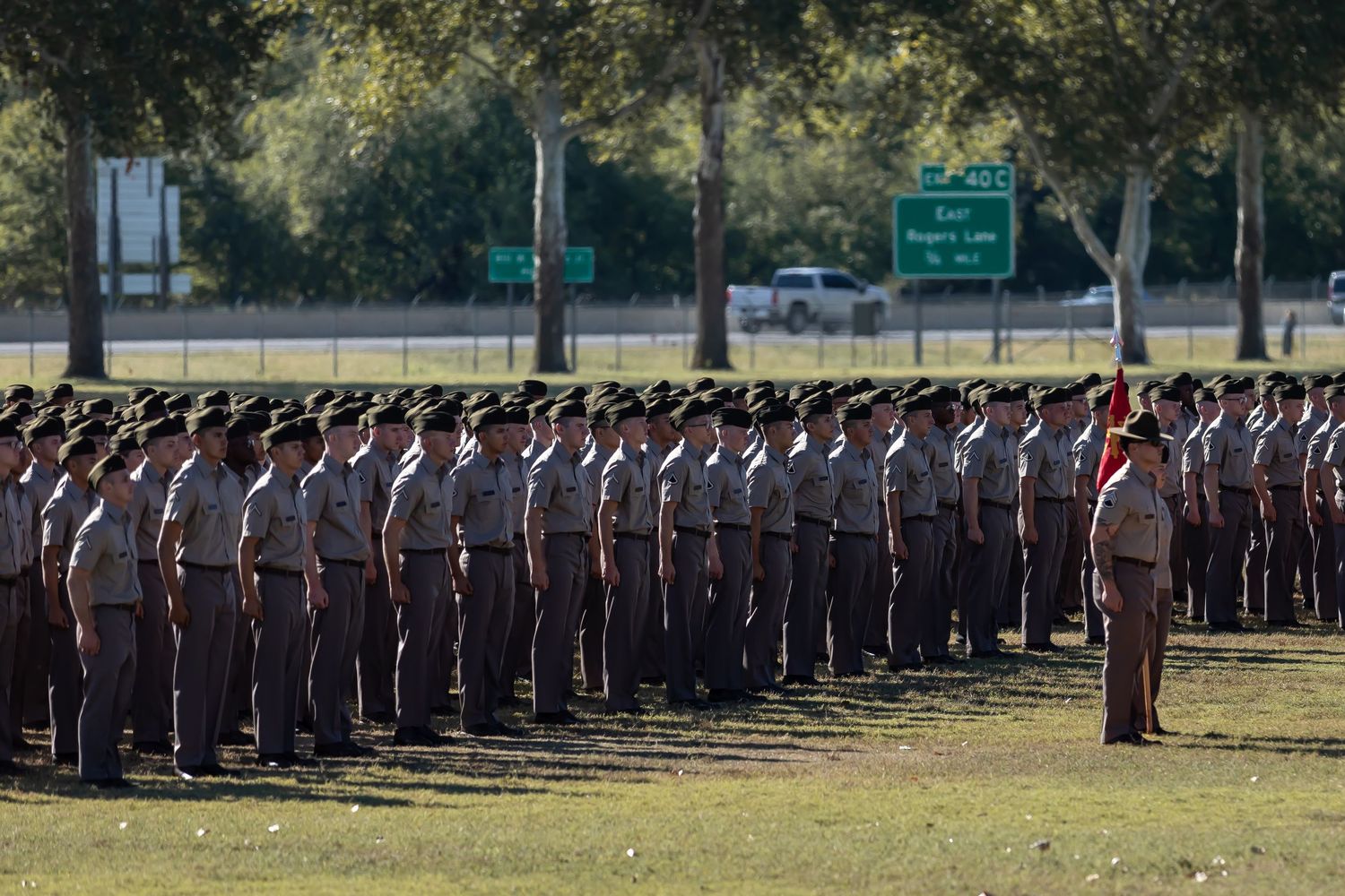 Military personnel standing at attention in formation during outdoor ceremony.