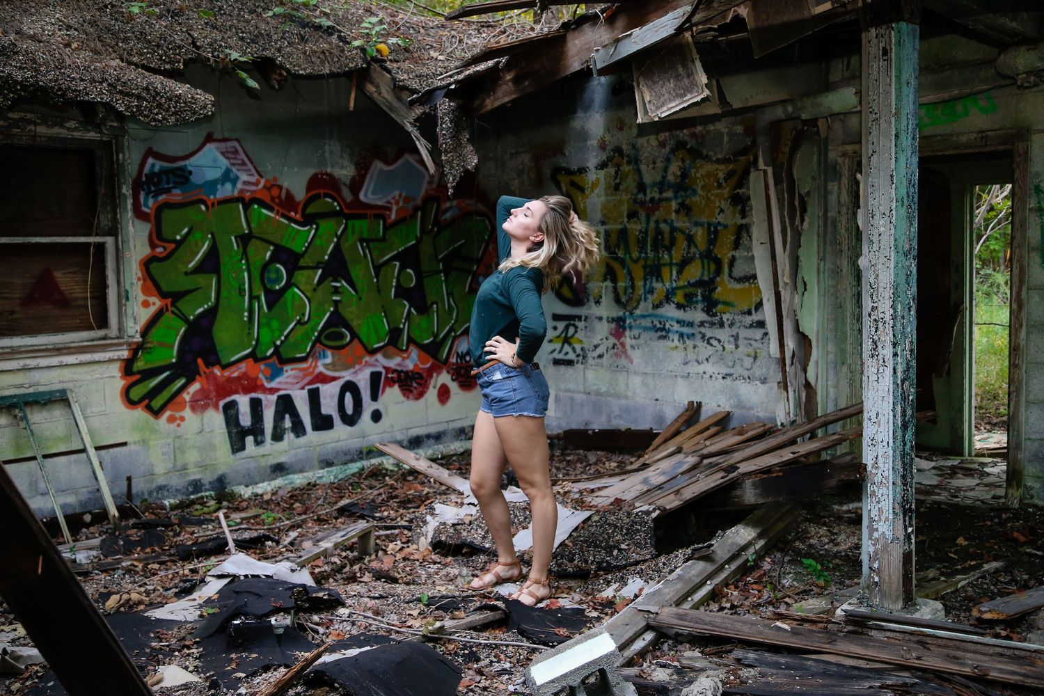 Decaying interior of an abandoned building with graffiti-covered walls and broken debris.