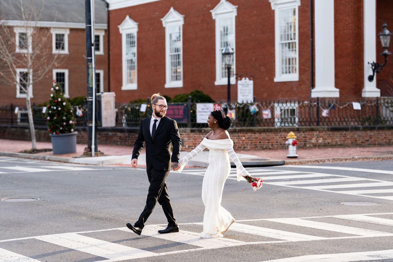 Couple walking across a brick-paved courtyard in formal attire.