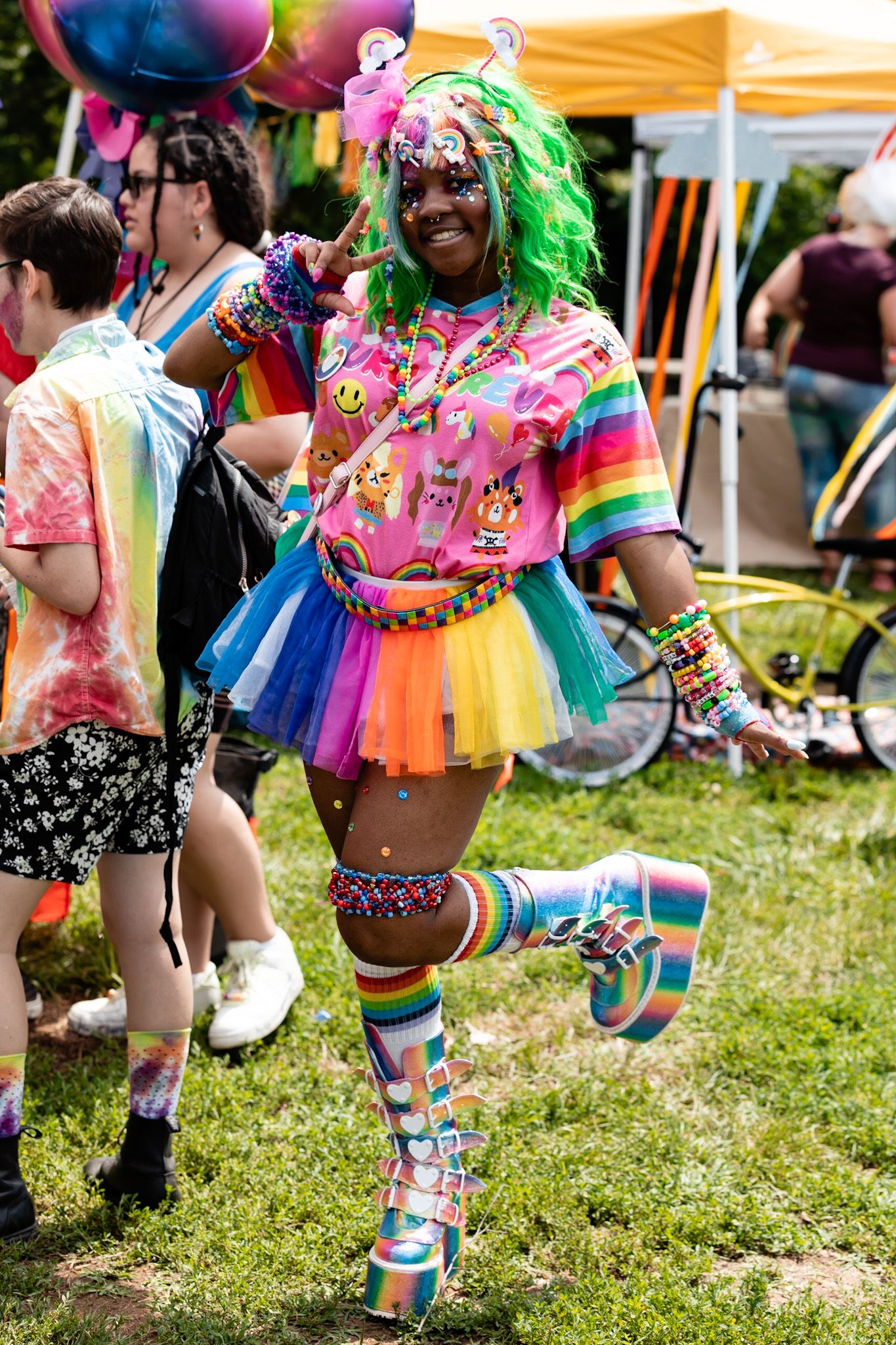 Dancers in vibrant rainbow tutus and colorful outfits performing at pride festival.
