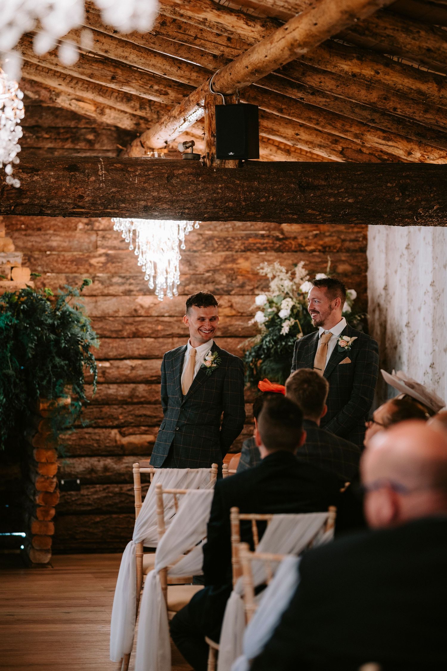 Wedding ceremony in a rustic wooden cabin venue with elegant decor and floral arrangements.