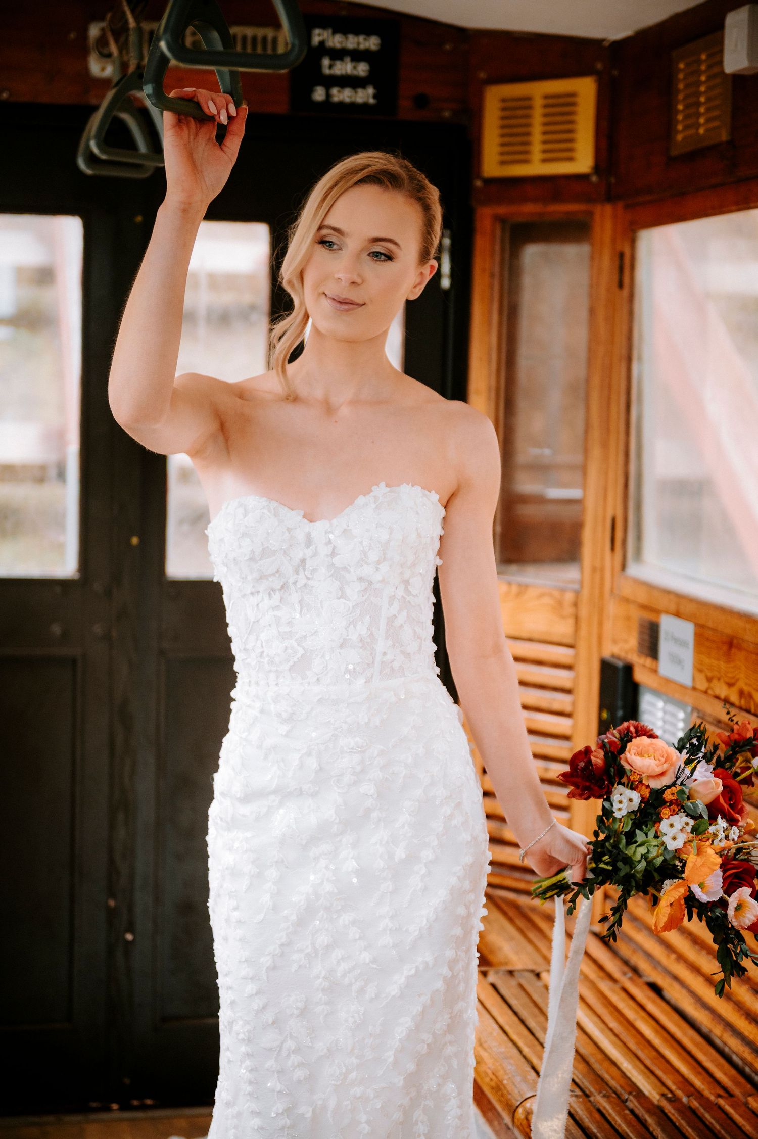 A romantic bridal portrait inside a historic wooden train car with warm lighting.