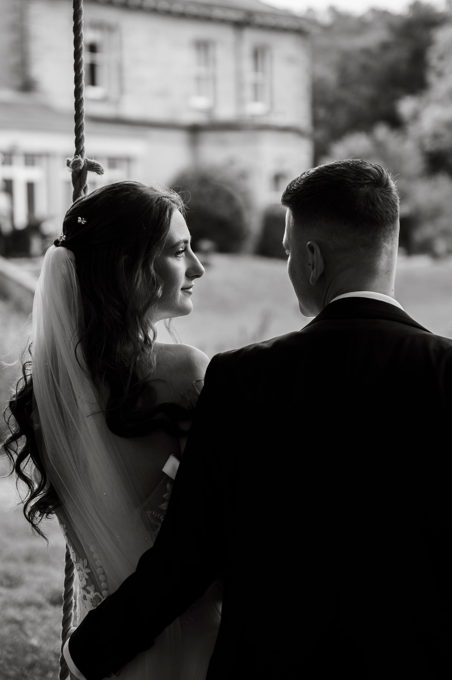 Black and white silhouettes of a couple in wedding attire sharing tender moments together.