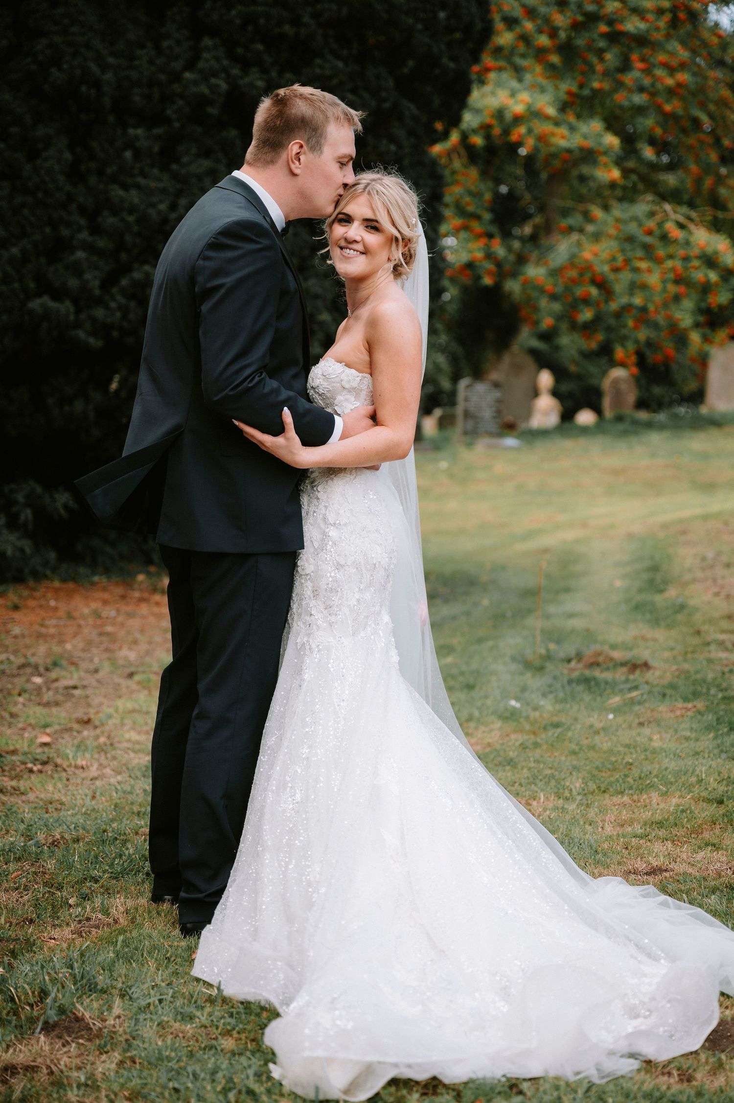 Romantic wedding couple shares intimate moment on autumn grounds.