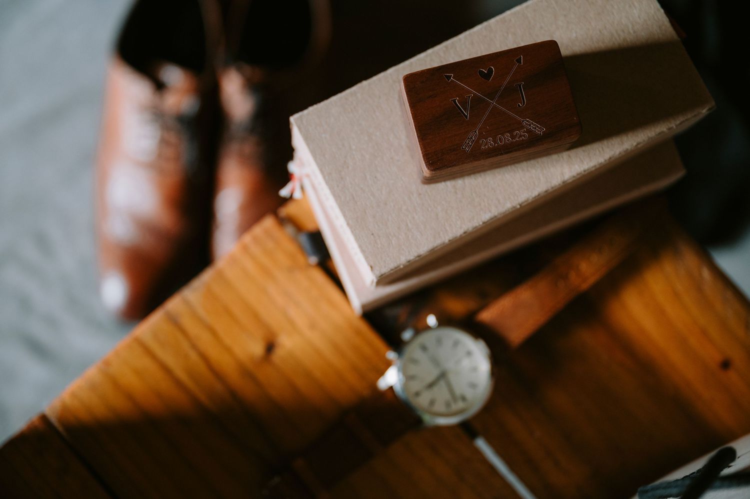 Close-up detail shot of wedding rings on a textured wooden surface.
