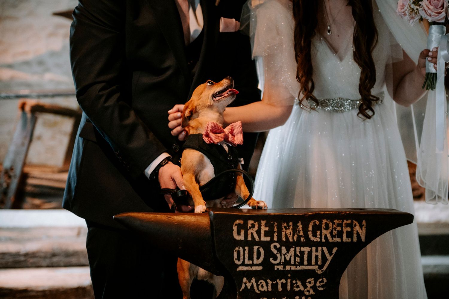 Close-up shot of hands on the historic Gretna Green anvil during a marriage ceremony.