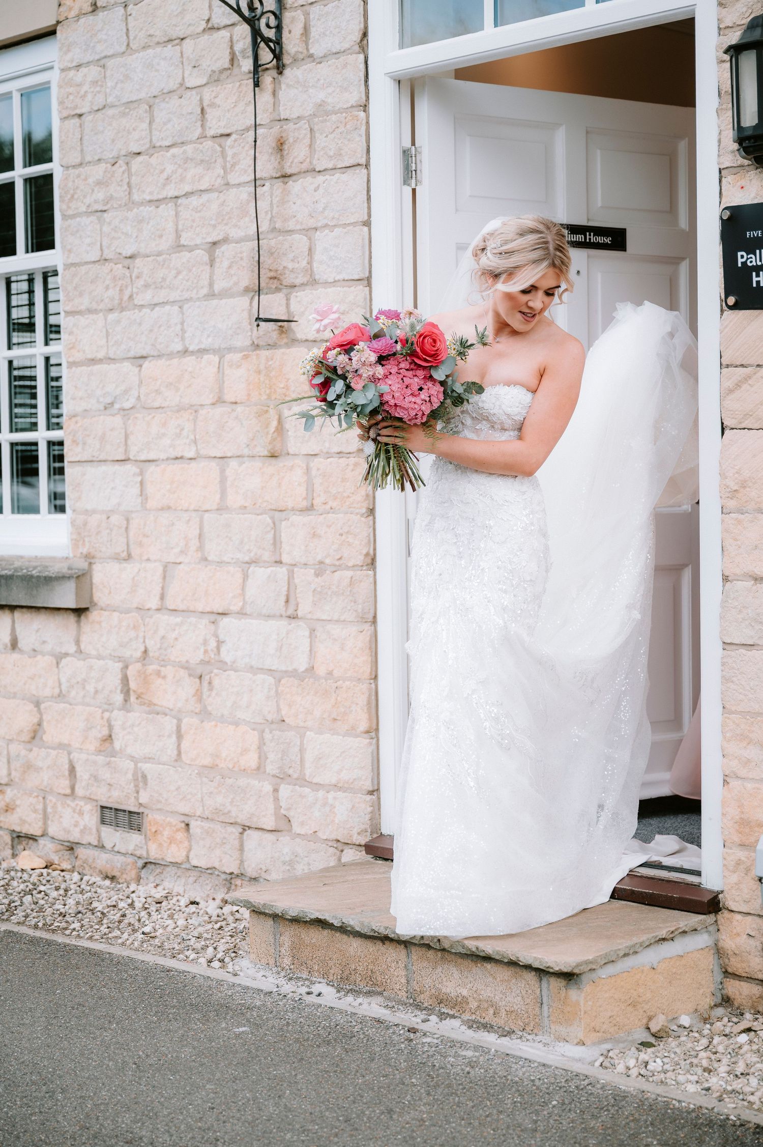 Playful bridal portraits against limestone building exterior.