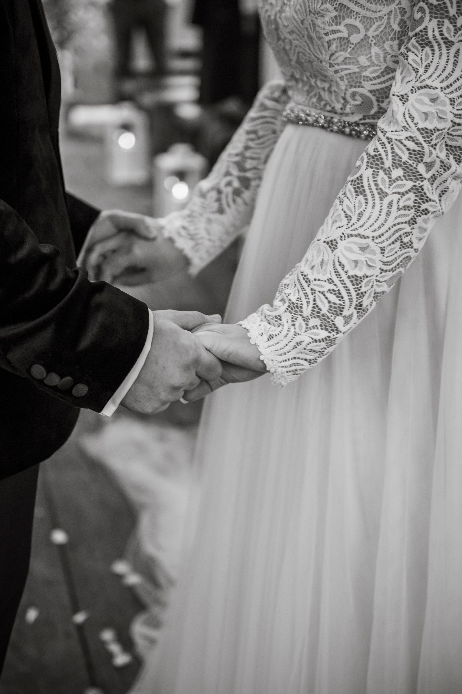 Detail shots of a white lace wedding dress with long sleeves during an intimate moment.