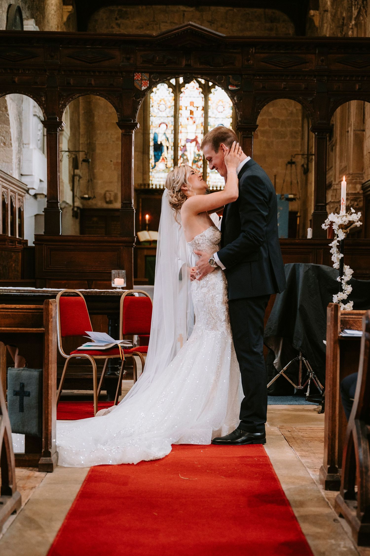 Wedding ceremony candid moments captured in sequence along a red-carpeted church aisle.