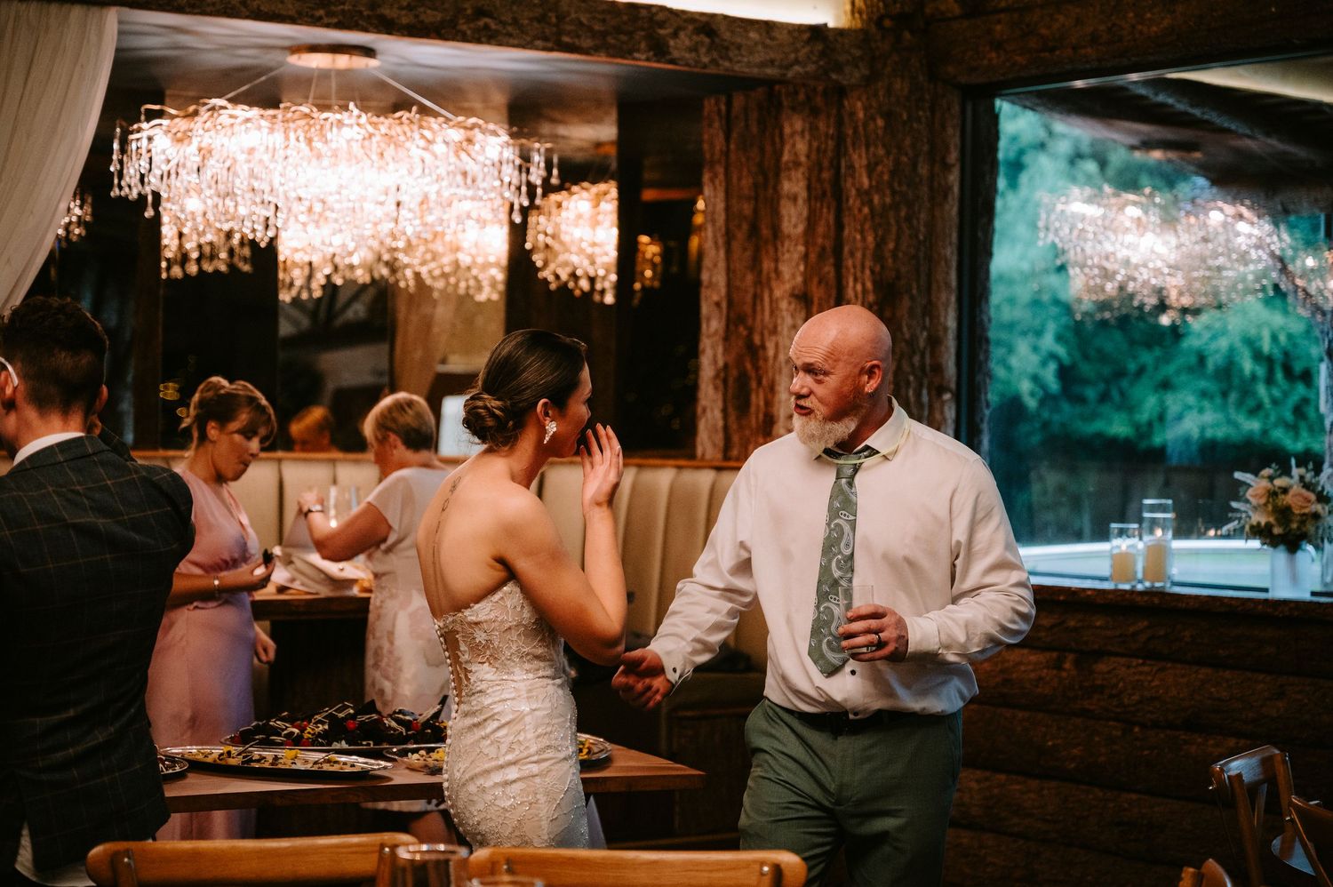 Guests enjoying an intimate indoor wedding reception with warm lighting and rustic decor.