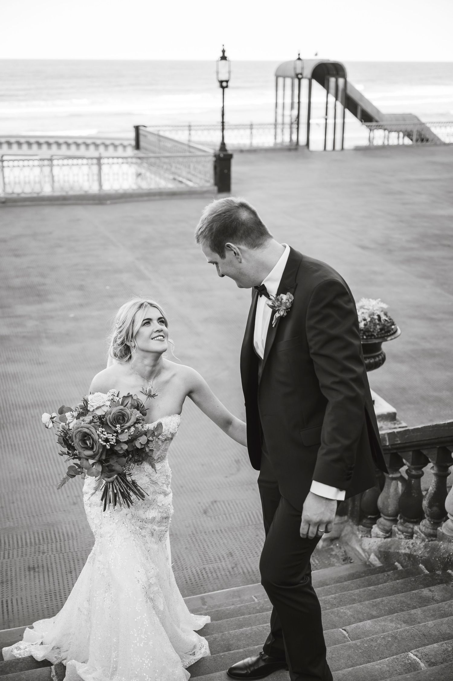 A romantic wedding photoshoot sequence on a beach boardwalk with dramatic lighting and ocean views.