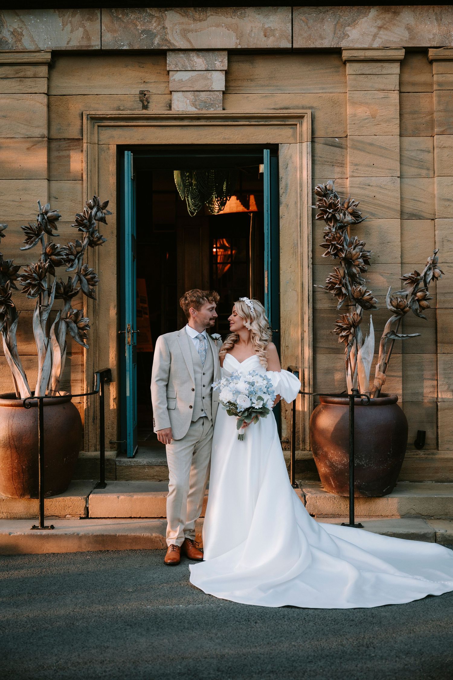 A wedding photoshoot against a rustic wooden building with turquoise accents.