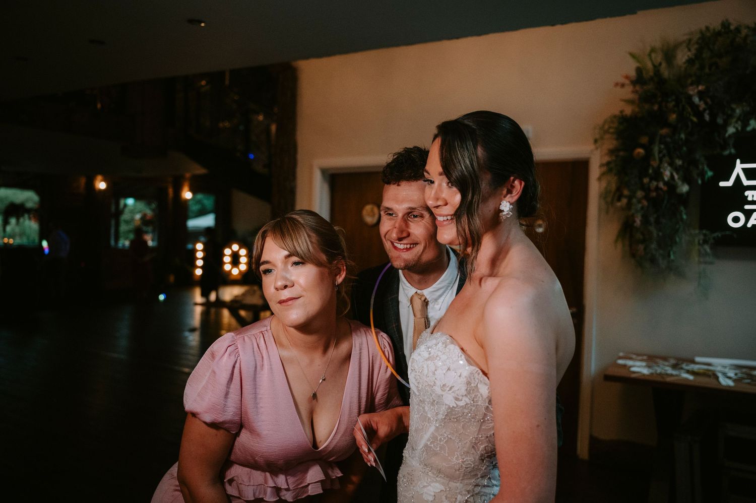 Wedding guests enjoying intimate conversation at dimly lit reception.